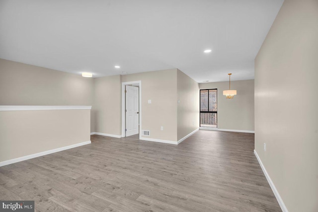 unfurnished room with visible vents, recessed lighting, wood finished floors, and baseboards