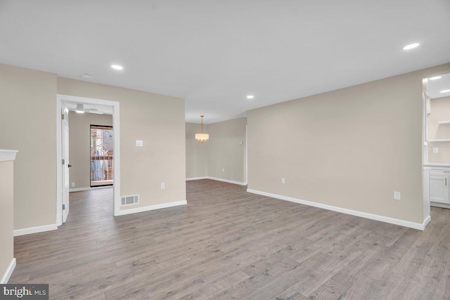 unfurnished living room with baseboards and light wood-type flooring