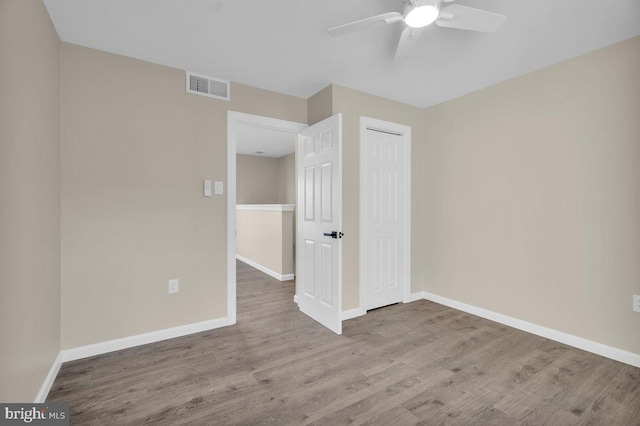 unfurnished bedroom with visible vents, baseboards, a closet, and wood finished floors