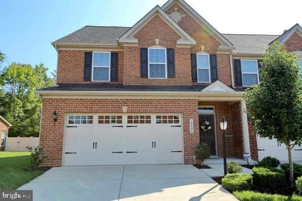 view of front of home featuring a garage, brick siding, and concrete driveway