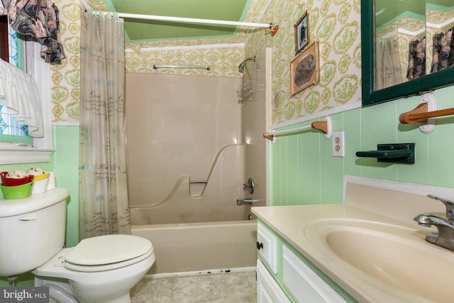 bathroom featuring vanity, wallpapered walls, wainscoting, toilet, and shower / tub combo with curtain