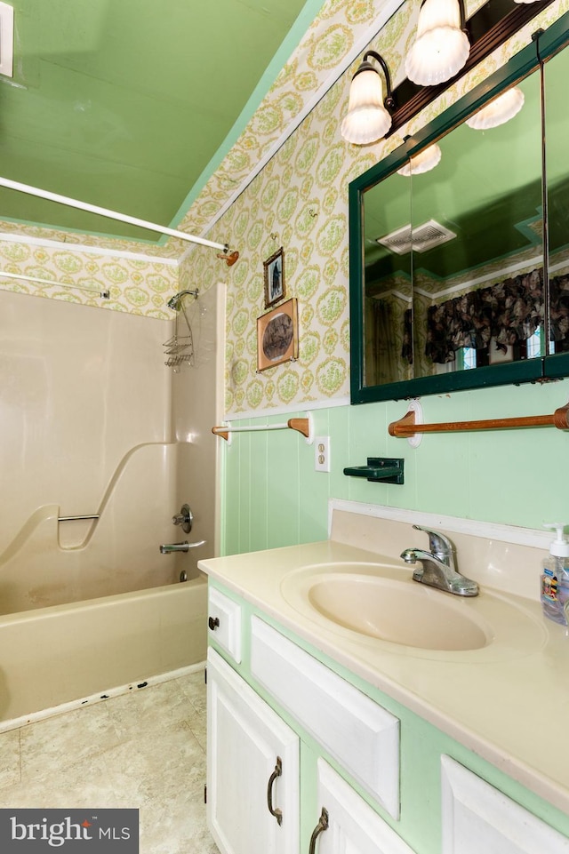 full bath with wallpapered walls, vanity, shower / bathtub combination, and wainscoting