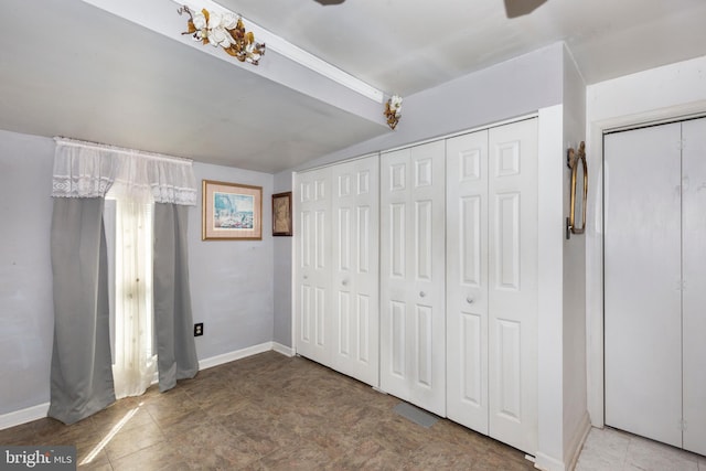 unfurnished bedroom featuring ceiling fan, baseboards, and vaulted ceiling