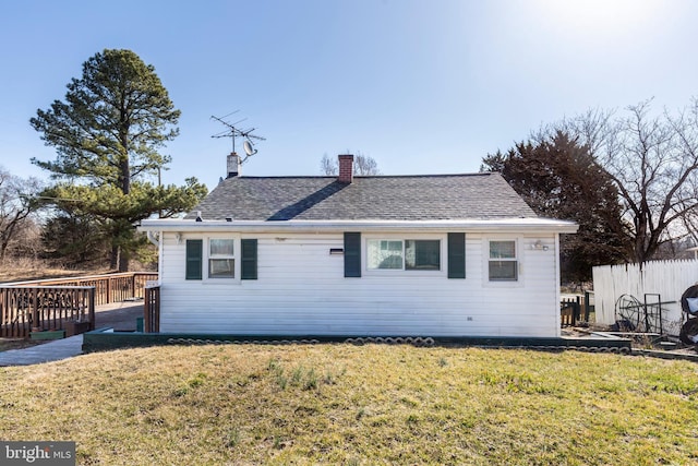 view of front of property with a front yard, fence, a chimney, and a wooden deck