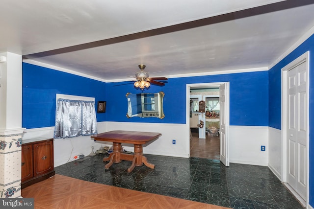 dining room featuring a ceiling fan and a wainscoted wall