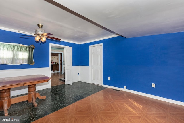 interior space with visible vents, baseboards, and ceiling fan