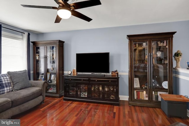 living room with a ceiling fan, wood finished floors, and baseboards