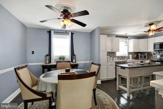 dining space featuring baseboards, dark wood-type flooring, and a ceiling fan