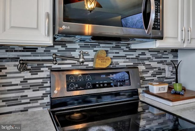 details featuring decorative backsplash, light countertops, white cabinets, and stainless steel appliances