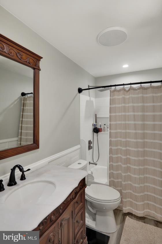 full bathroom with toilet, vanity, and wood finished floors