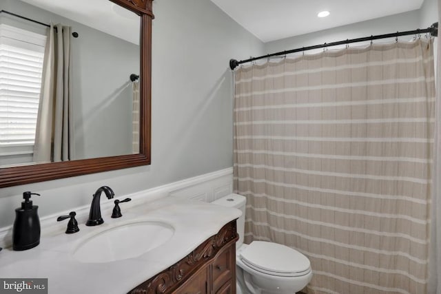 bathroom with vanity, toilet, and wainscoting