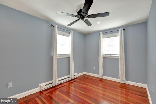 unfurnished room with baseboard heating, a ceiling fan, baseboards, and wood finished floors