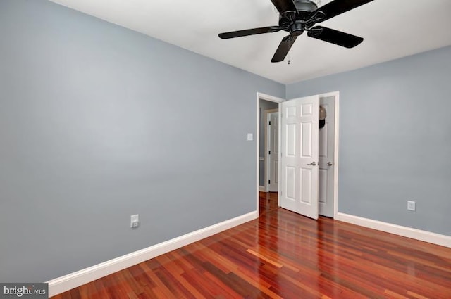 empty room featuring ceiling fan, baseboards, and wood finished floors