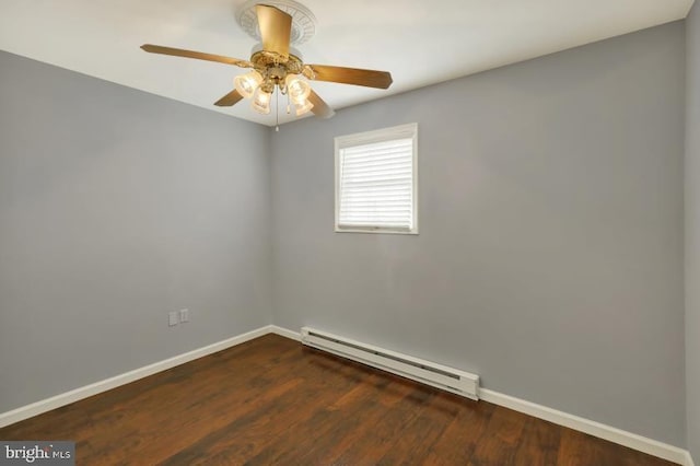 unfurnished room featuring a baseboard heating unit, wood finished floors, and baseboards