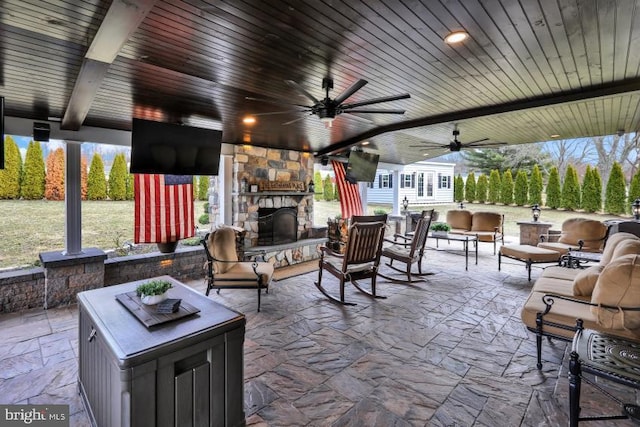 view of patio / terrace with an outdoor living space with a fireplace and ceiling fan