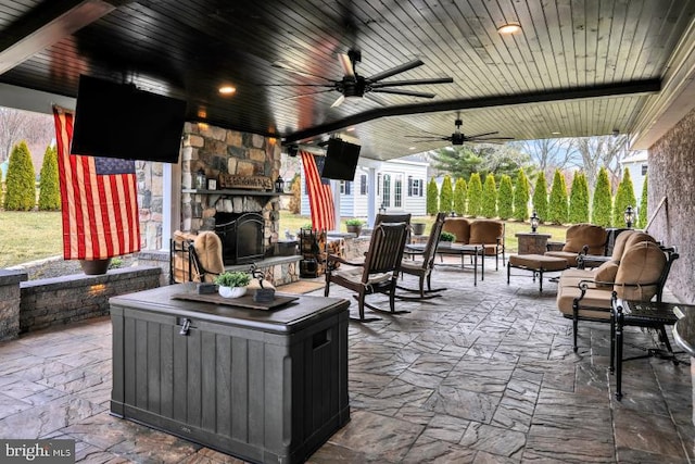 view of patio with an outdoor living space with a fireplace and a ceiling fan