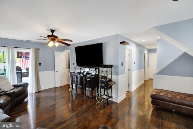 living room featuring a ceiling fan, wood finished floors, and wainscoting