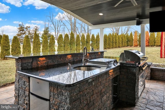 view of patio featuring area for grilling, a ceiling fan, and a sink