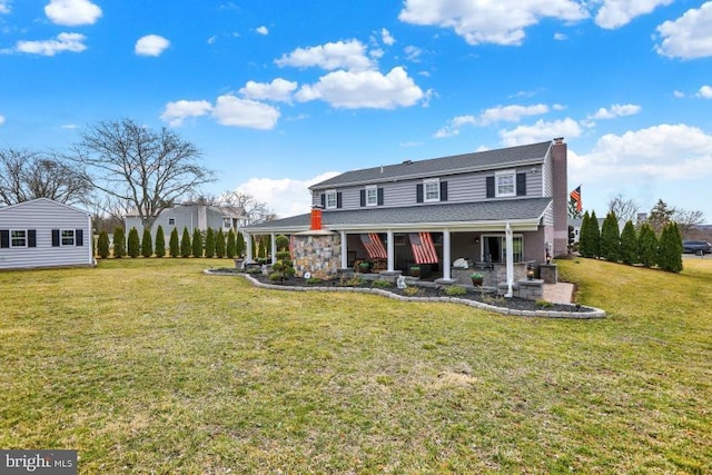 view of front of house featuring a porch, a chimney, and a front yard