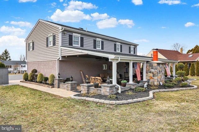 rear view of house with a patio, a lawn, and stucco siding