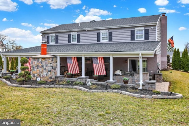 view of front of home featuring a shingled roof, a front lawn, stone siding, and a chimney