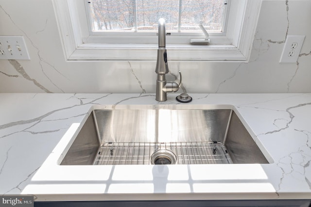 details featuring a sink and light stone counters