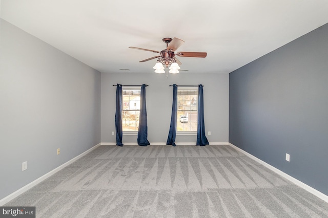 spare room with baseboards, carpet, and a ceiling fan