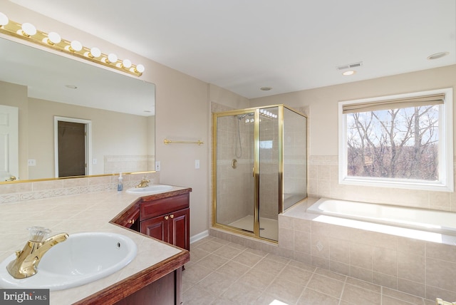 full bath with visible vents, a sink, a shower stall, double vanity, and a bath