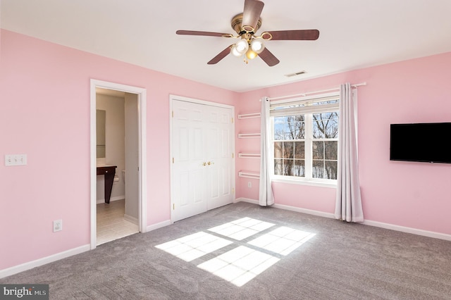 unfurnished bedroom with visible vents, connected bathroom, baseboards, carpet, and a closet