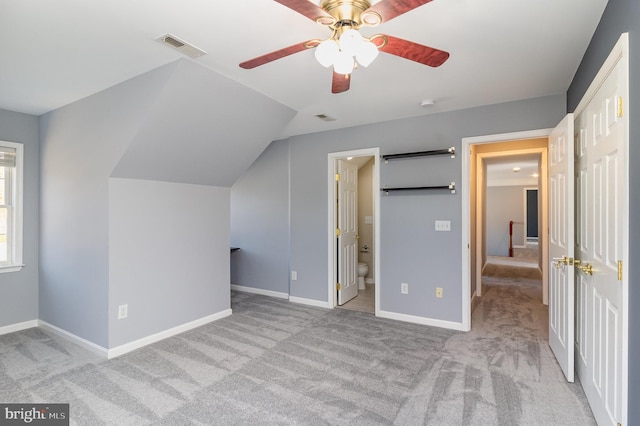 unfurnished bedroom with visible vents, baseboards, carpet floors, connected bathroom, and lofted ceiling