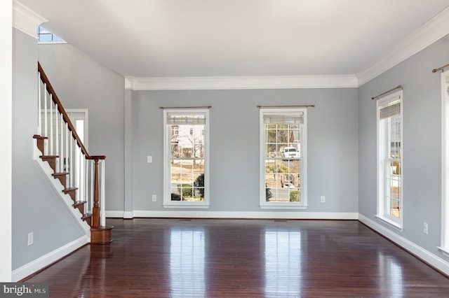 spare room with crown molding, dark wood-type flooring, and baseboards