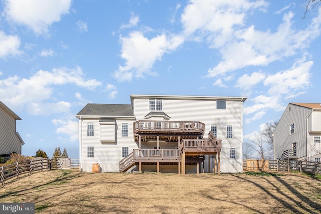 back of property with a wooden deck, a fenced backyard, and stairs