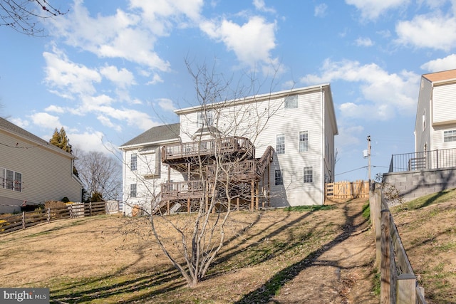 back of property with stairs, a deck, and fence