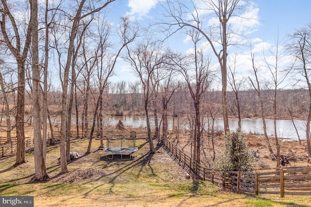 property view of water with fence and a forest view