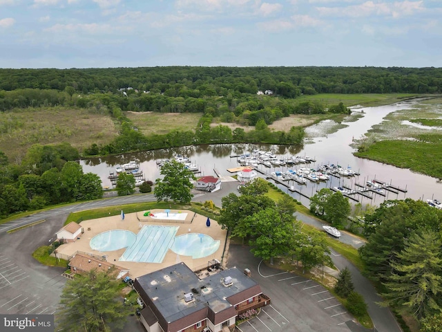 drone / aerial view with a wooded view and a water view