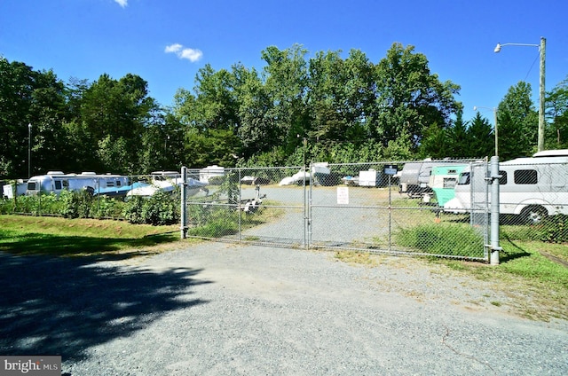 view of street with a gated entry, driveway, street lighting, and a gate