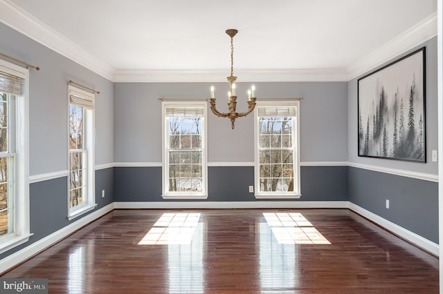 unfurnished dining area featuring crown molding, wood finished floors, and baseboards