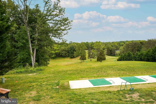 surrounding community with a yard and a wooded view