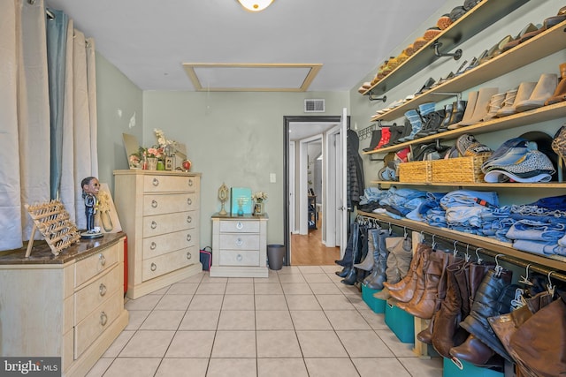 walk in closet featuring attic access, light tile patterned flooring, and visible vents