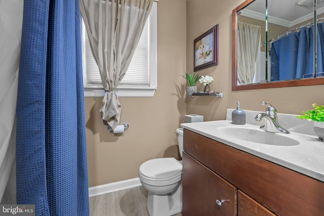 full bath featuring vanity, wood finished floors, baseboards, crown molding, and toilet