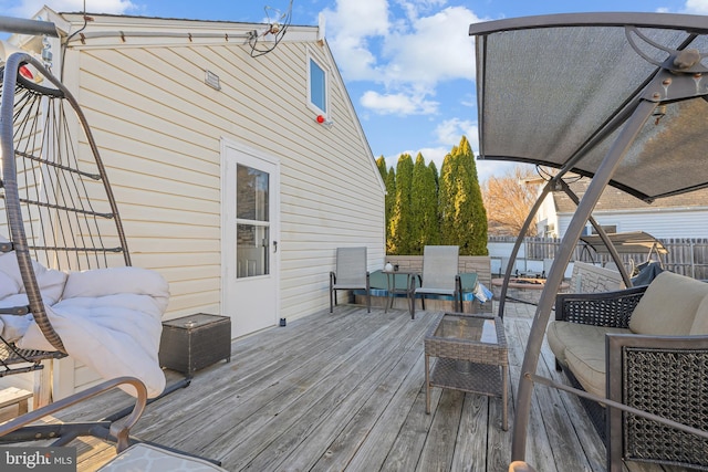 deck featuring an outdoor hangout area and fence