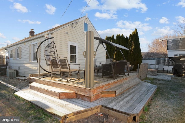 back of property with a wooden deck, central AC unit, fence, and a chimney