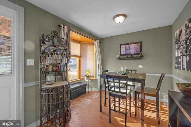 dining area featuring baseboards and hardwood / wood-style flooring