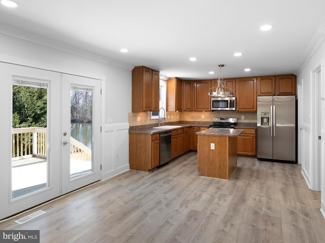 kitchen featuring visible vents, french doors, brown cabinetry, stainless steel appliances, and a sink