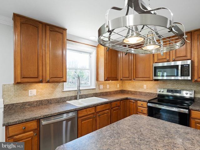 kitchen with a sink, dark countertops, and appliances with stainless steel finishes