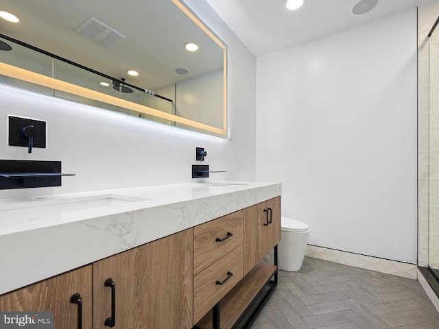 bathroom featuring visible vents, double vanity, recessed lighting, toilet, and a shower with door