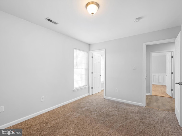 unfurnished bedroom featuring visible vents, baseboards, and carpet floors