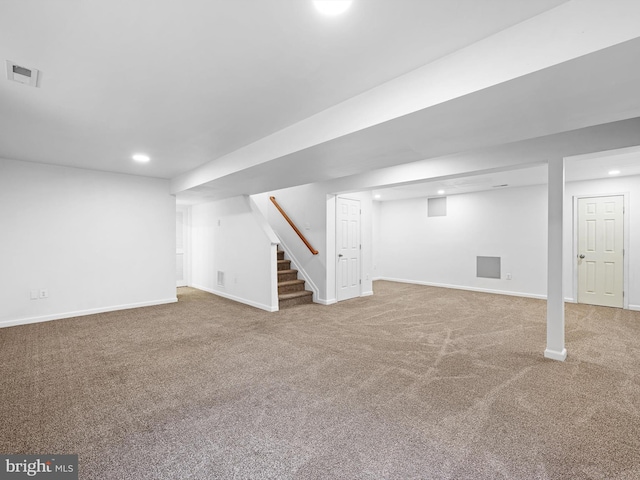 finished below grade area with visible vents, recessed lighting, stairway, carpet floors, and baseboards