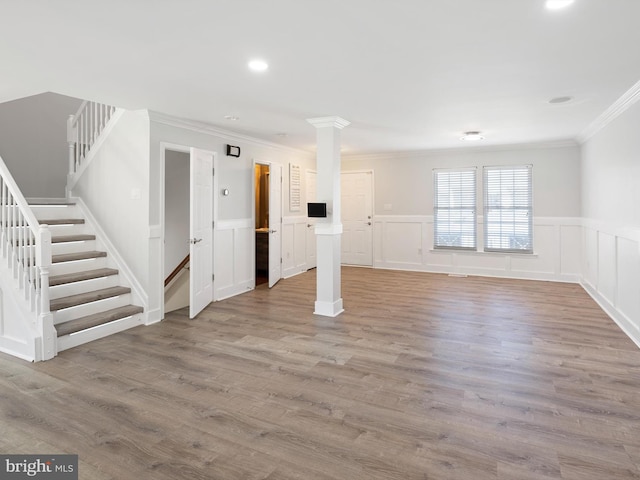 basement with ornamental molding, wood finished floors, recessed lighting, wainscoting, and stairs