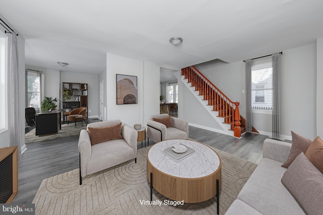 living room with baseboards, wood finished floors, and stairs